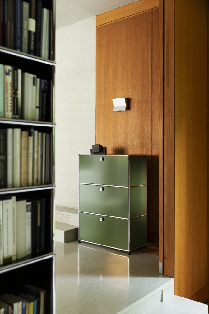 USM Haller Highboard in Olivgrün mit drei Klapptüren, modernes Designmöbel für stilvolle Wohnräume.